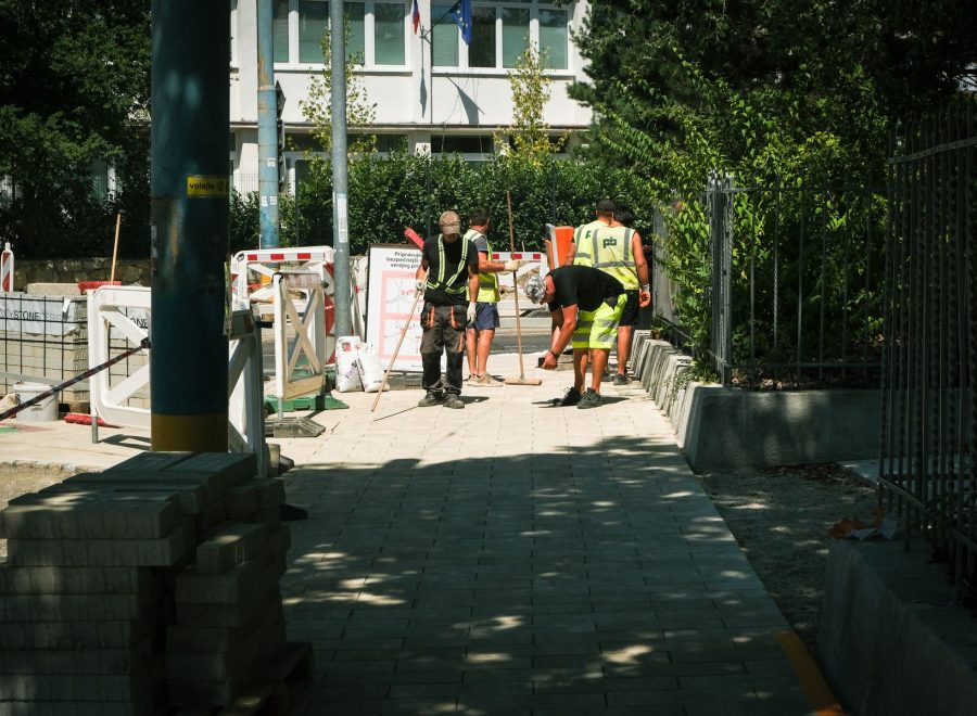 Baustellenbereich einer Außenanlage mit Arbeitern in Warnkleidung